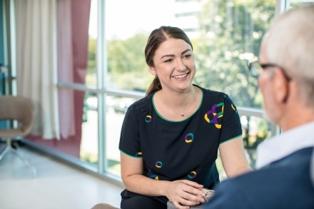 Care team member counselling cancer patient undergoing treatment.