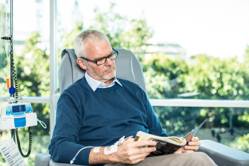 A cancer patient reading a book while being treated.