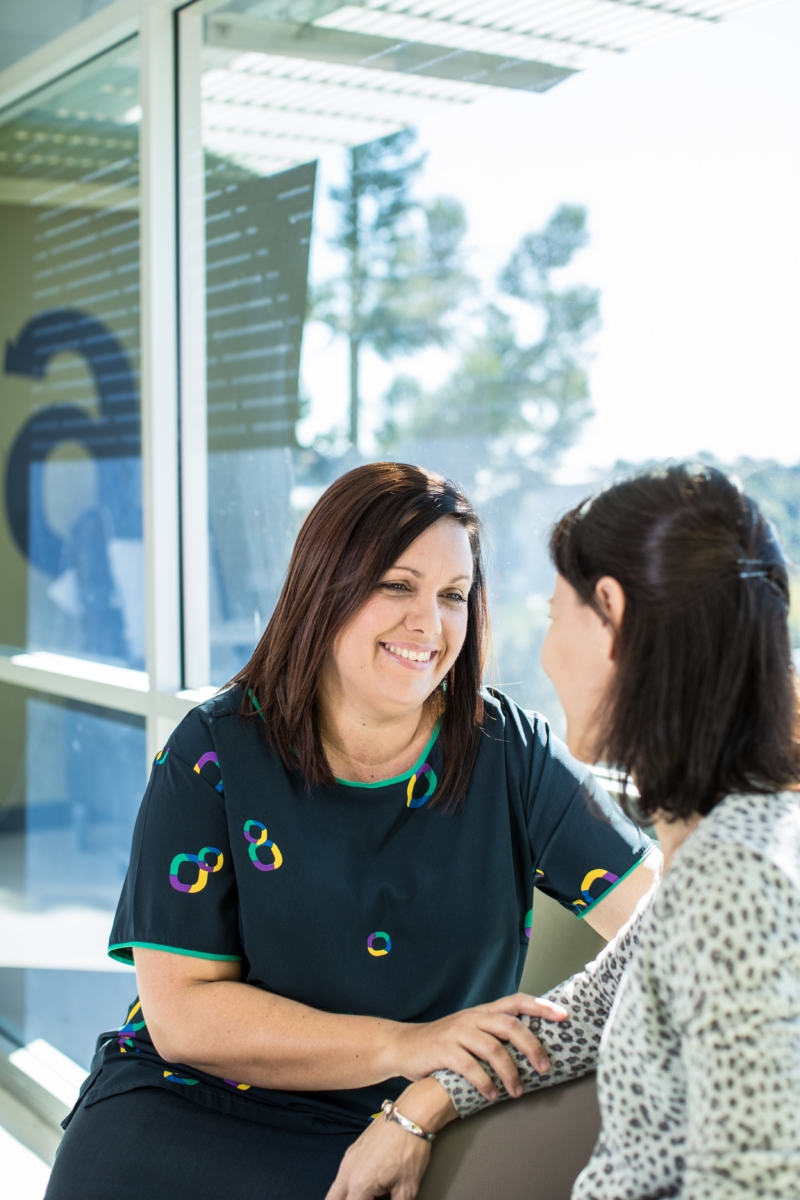 Cancer treatment therapist comforting a cancer patient.
