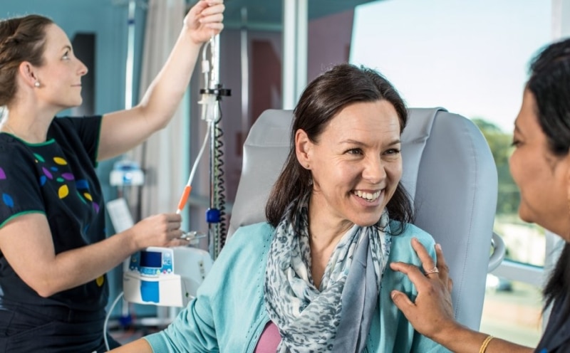 Laughing cancer patient with care team