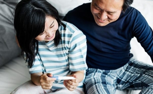 Couple smiling at pregnancy test
